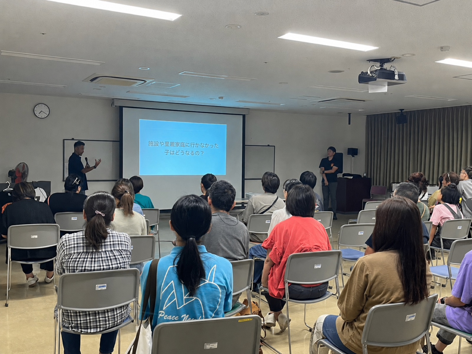 うるま市で開催した自主開催お話会の様子。スクリーンに「施設や里親家庭に行かなかった子はどうなるの？」と映し、約50名が参加した