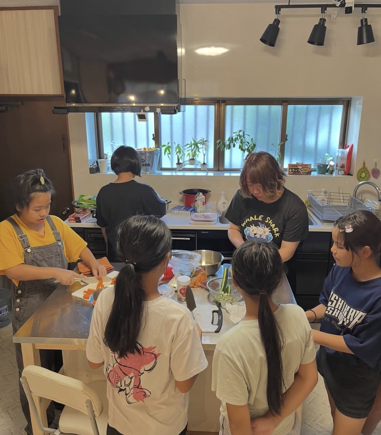 キッチンで野菜を切ったり盛り付けたりする子どもたち