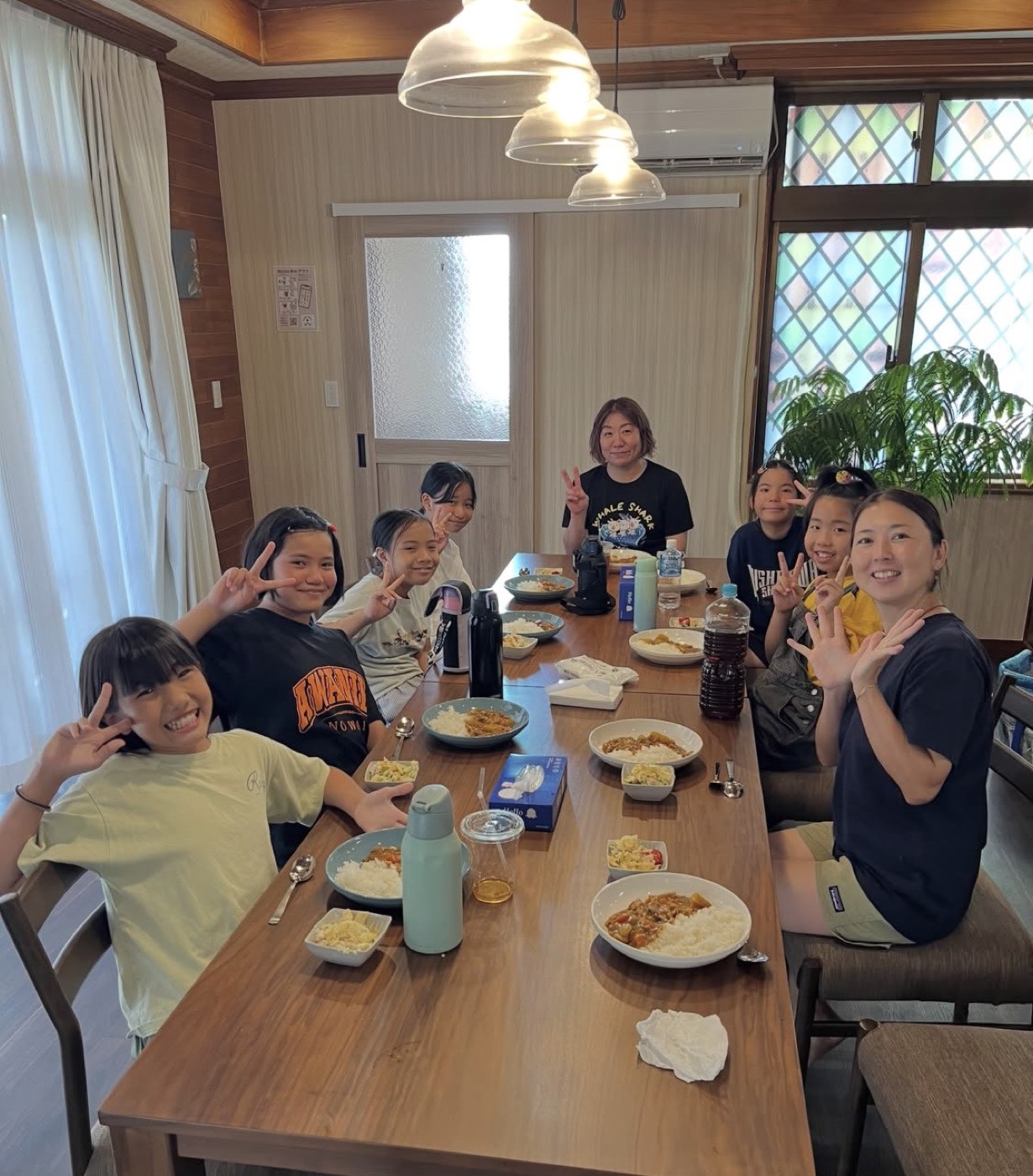 自分たちで買い出し・調理したカレーとポテトサラダを囲む子どもたちとスタッフ