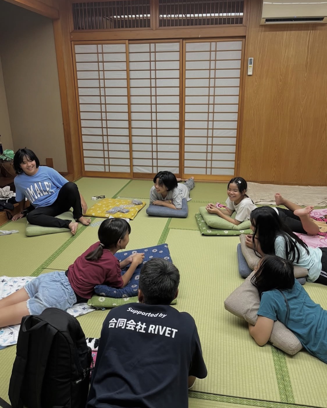 和室で寝そべりながら夜遅くまで話し込む子どもたち