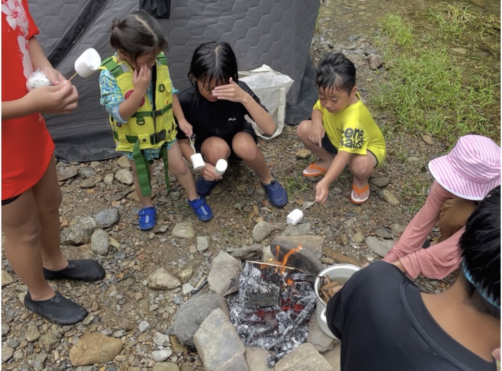 焚き火でマシュマロを焼く子どもたち